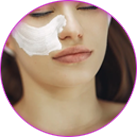 Facial Services in Orange, CA Woman receiving a facial treatment with a cream mask applied to her cheek