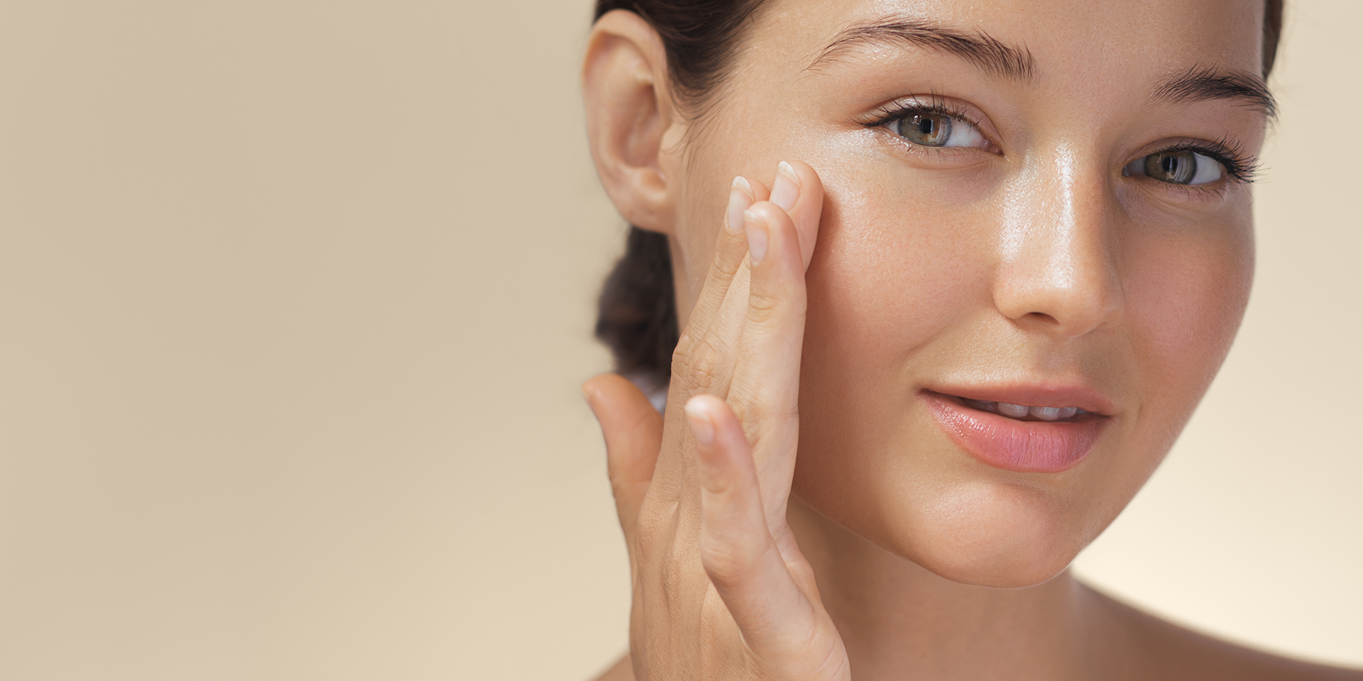 Woman touching smooth, glowing skin after chemical peel treatment in Orange, CA